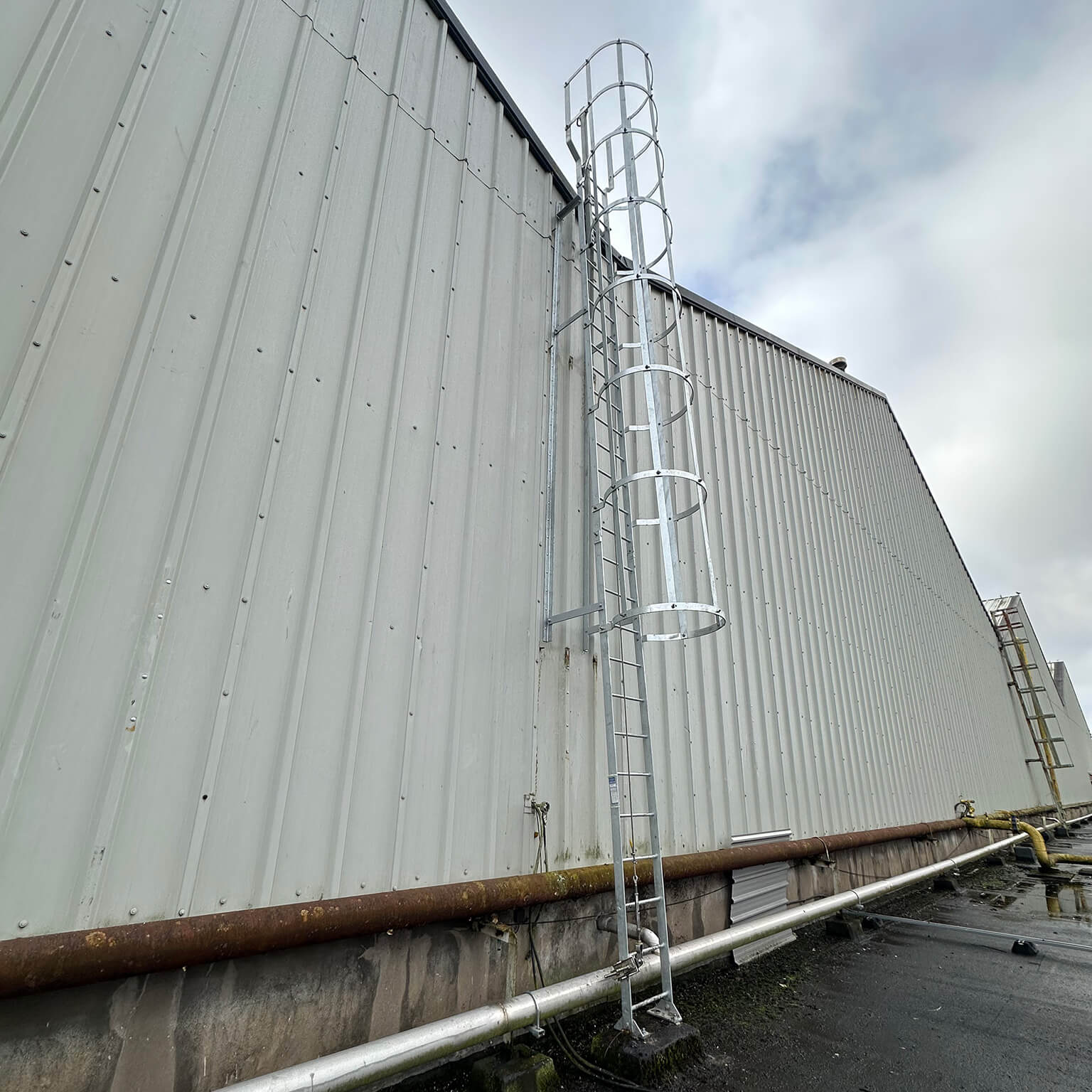 External roof access ladder with safety hoop.